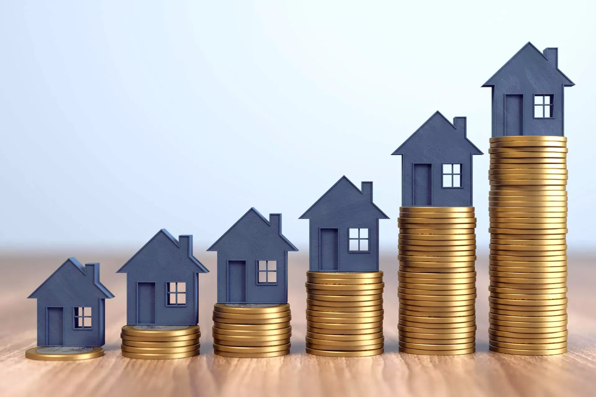Steigende Immobilienpreise: Von links nach rechts ansteigende Münzstapel mit grauen Hausmodellen obenauf. Steigende Immobilienpreise: Von links nach rechts ansteigende Münzstapel mit grauen Hausmodellen obenauf.