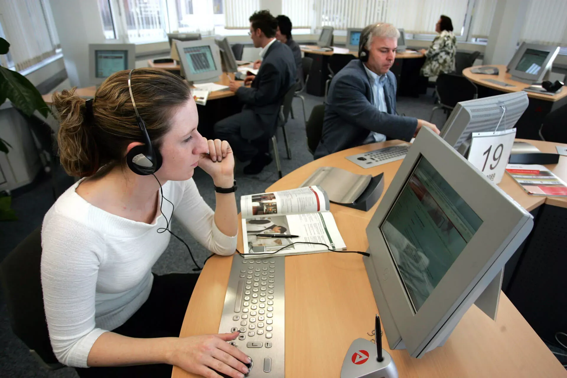 Sachbearbeiterin in Arbeitsagentur telefoniert mit Headset. Sachbearbeiterin in Arbeitsagentur telefoniert mit Headset.
