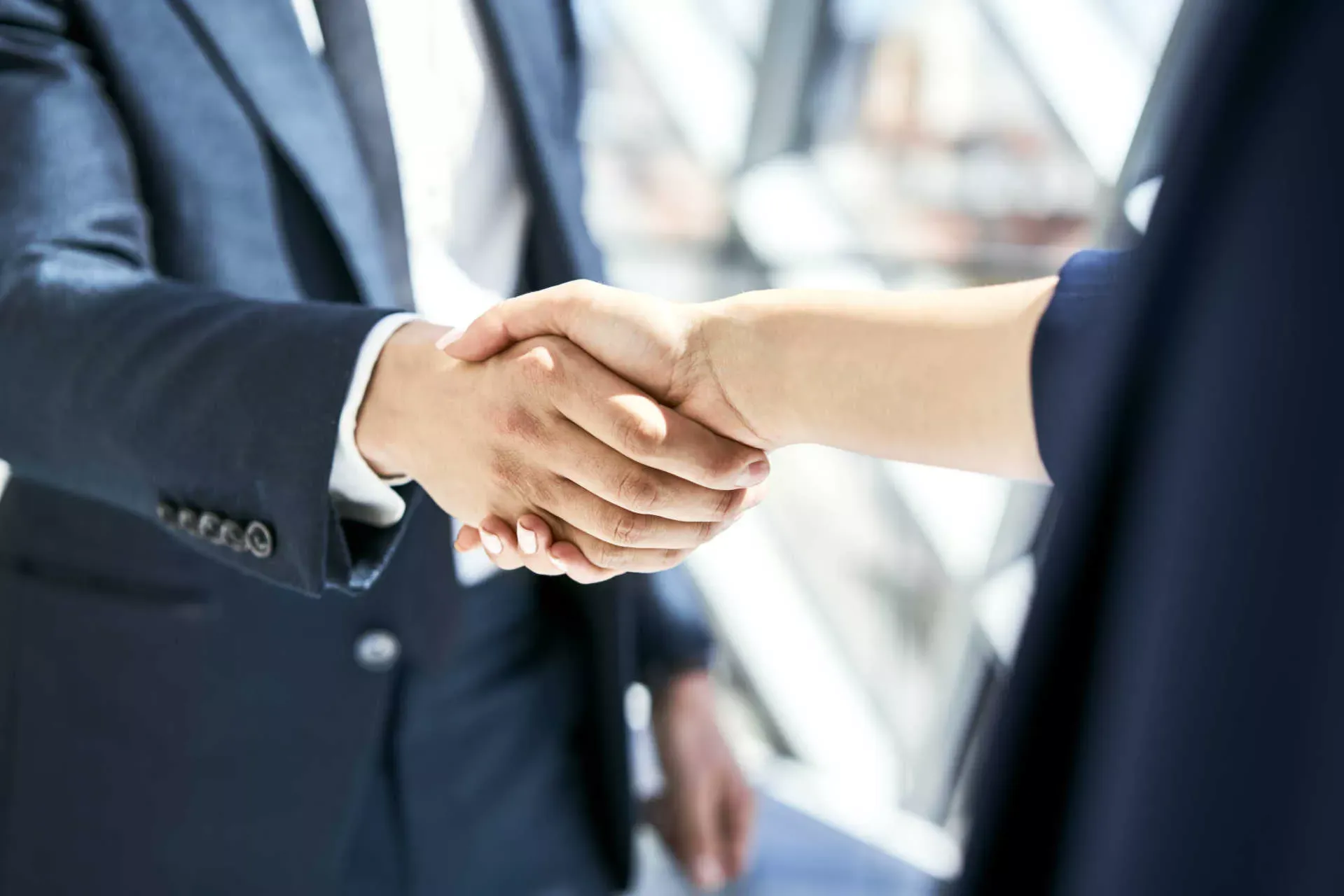 Handshake zwischen Frau und Mann in Busineskleidung. Bild: IMAGO / Westend61 / Bartek Szewczyk