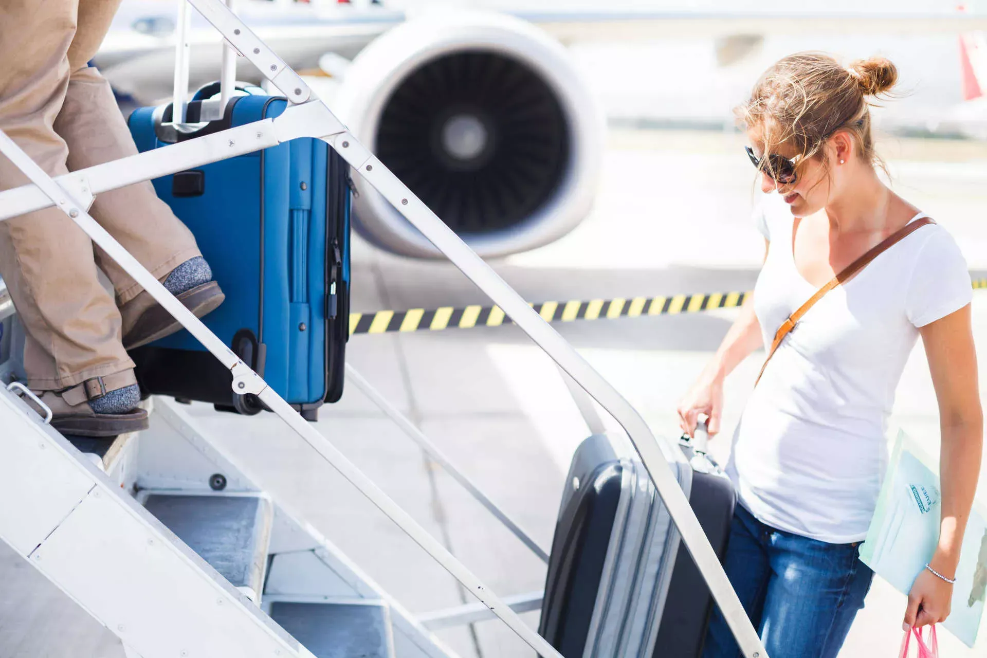 Frau mit Sonnenbrille und Koffer auf Gangway beim Boarding eines Flugzeugs. Bild: IMAGO / Panthermedia / Lightpoet Frau mit Sonnenbrille und Koffer auf Gangway beim Boarding eines Flugzeugs. Bild: IMAGO / Panthermedia / Lightpoet