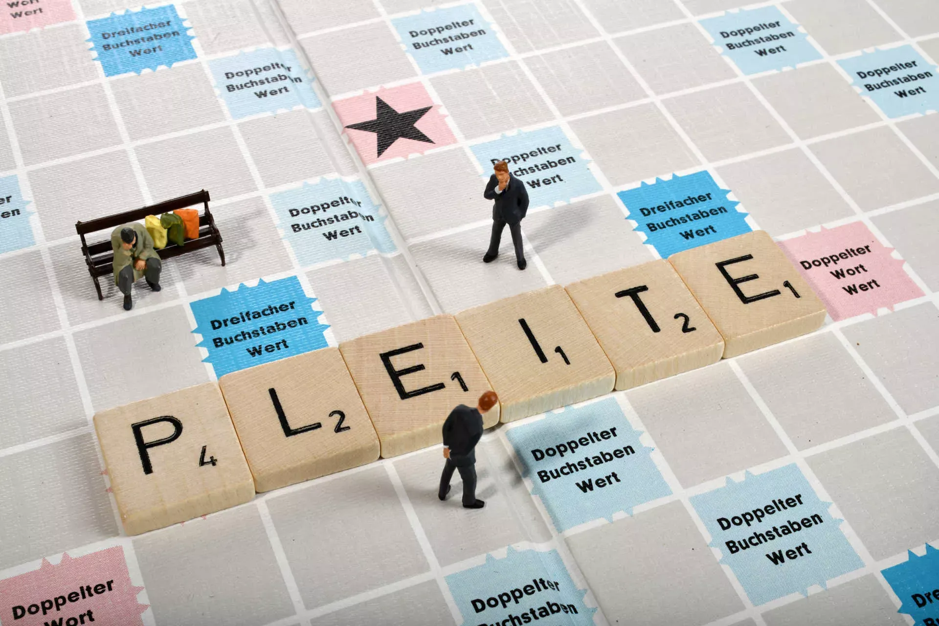 Scrabble-Spiel mit Buchstaben "Pleite" und Spielfiguren. Bild: IMAGO / Michael Weber