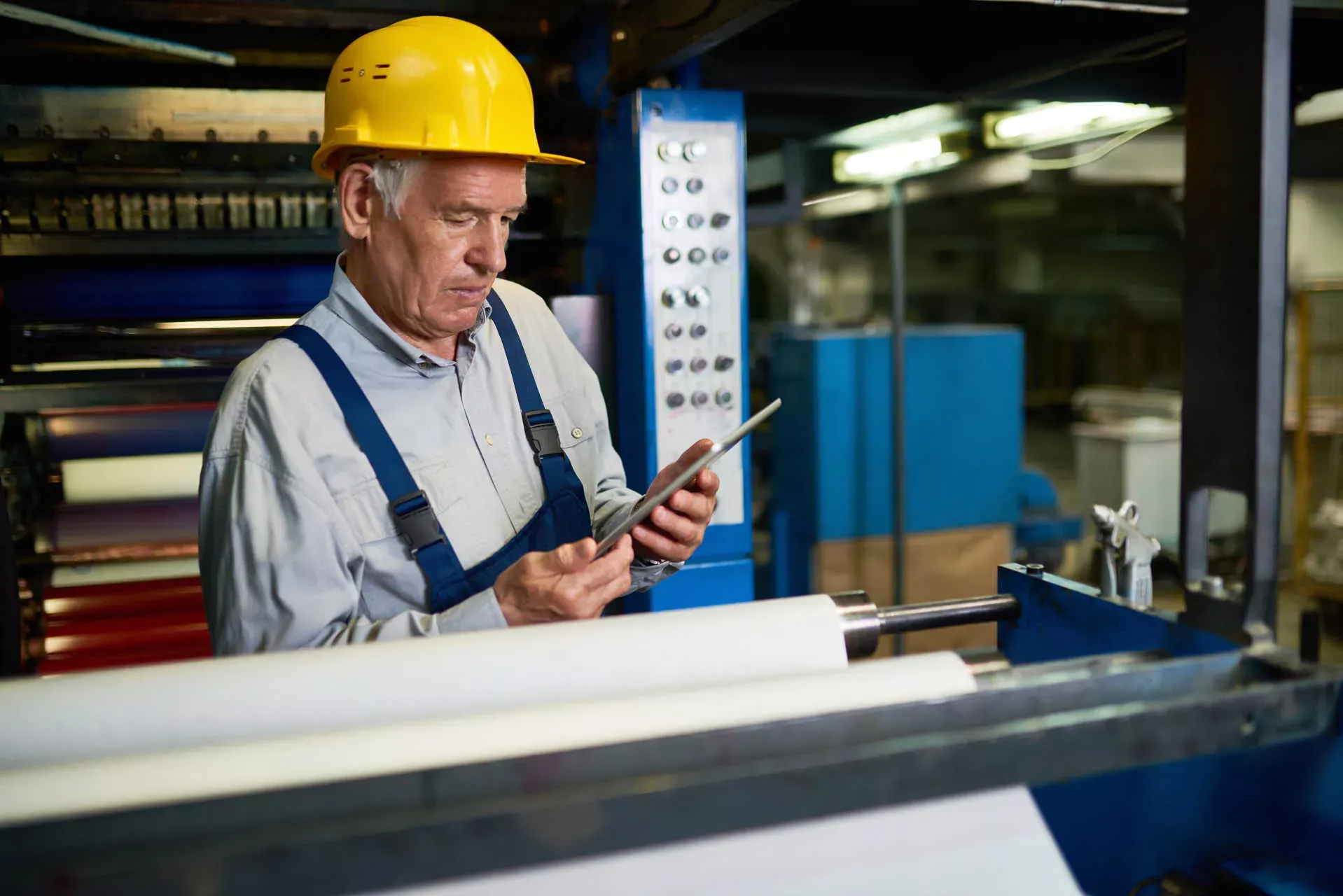 Arbeiter im Rentenalter in Fabrik mit gelbem Helm und Tablet. Bild: IMAGO / agefotostock / SeventyFour Arbeiter im Rentenalter in Fabrik mit gelbem Helm und Tablet. Bild: IMAGO / agefotostock / SeventyFour