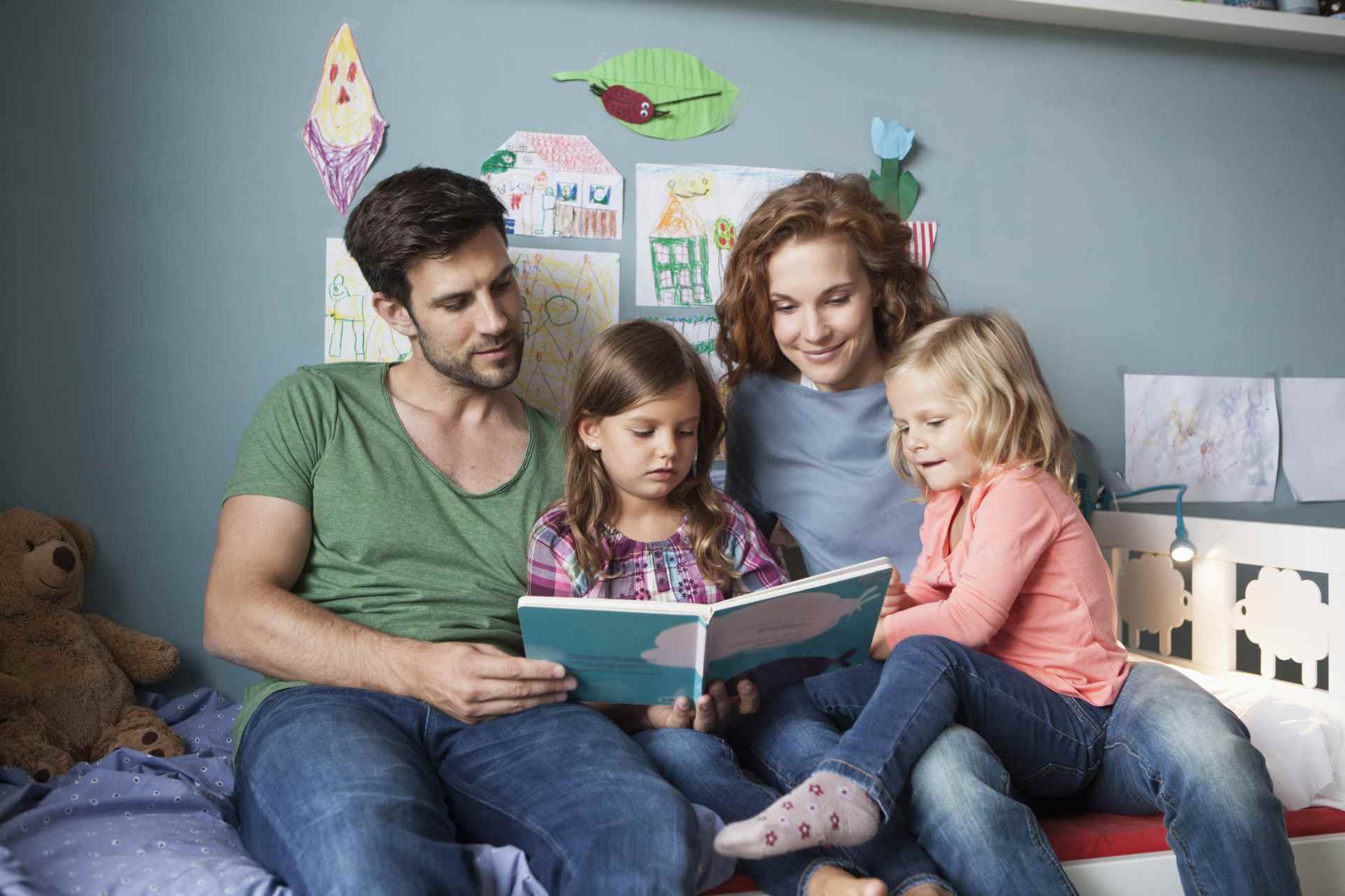 Junge Familie liest gemeinsam ein Bilderbuch.