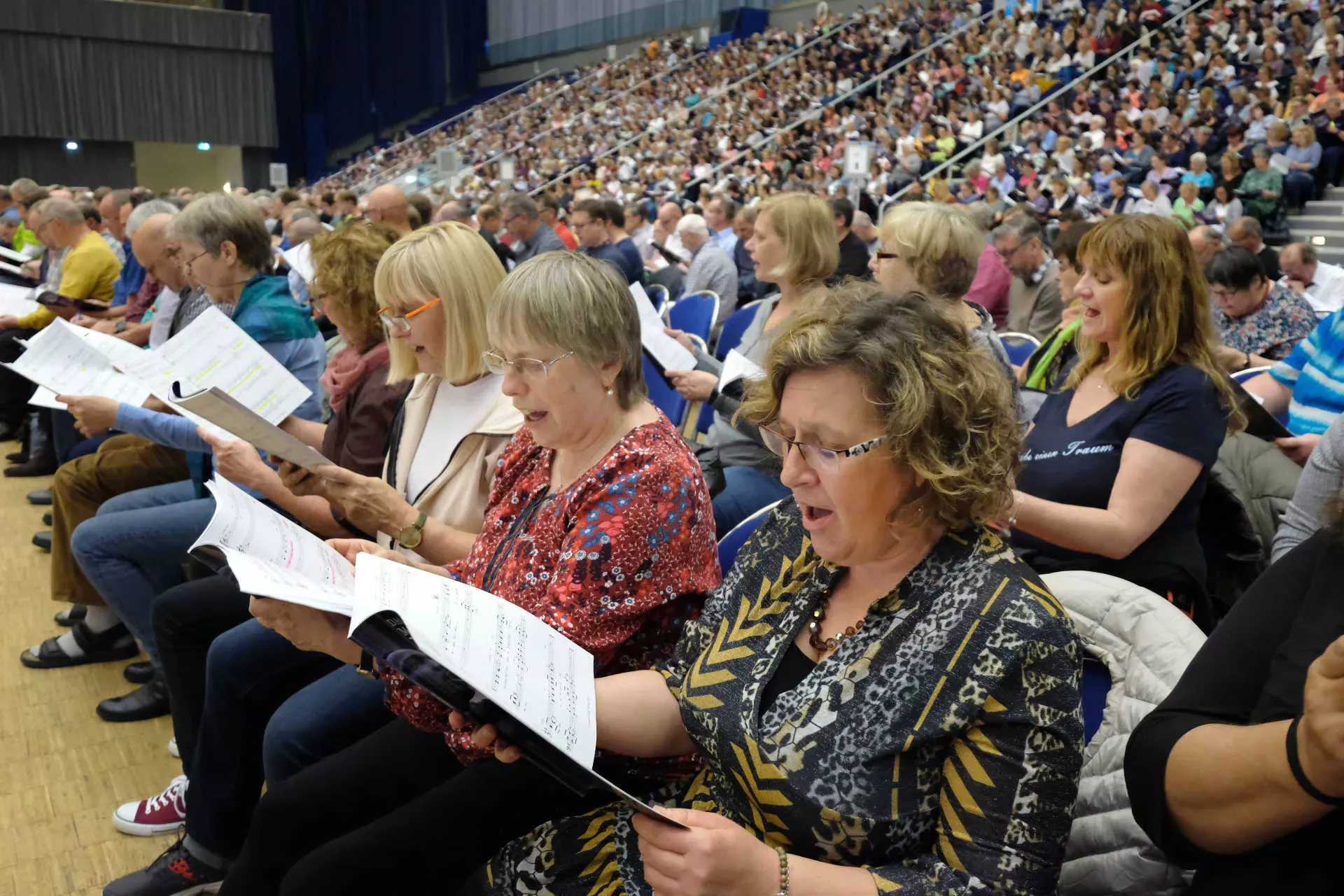 Beschreibung: Großer Chor probt in einer Halle. Bild: IMAGO / epd / Stefan Arend Großer Chor probt in einer Halle. Bild: IMAGO / epd / Stefan Arend