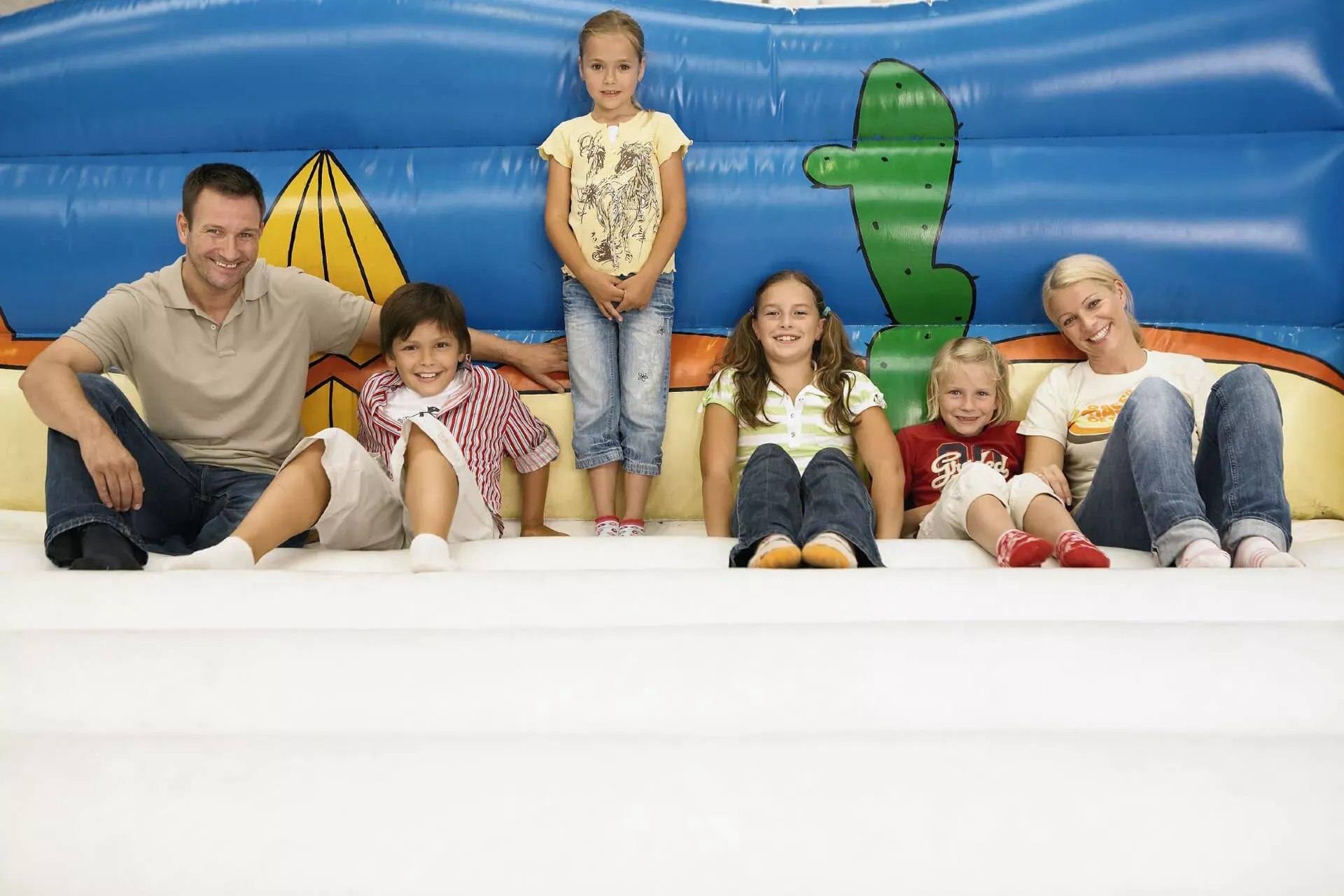 Eltern mit vier Kindern sitzen in einer Hüpfburg. Eltern mit vier Kindern sitzen in einer Hüpfburg.