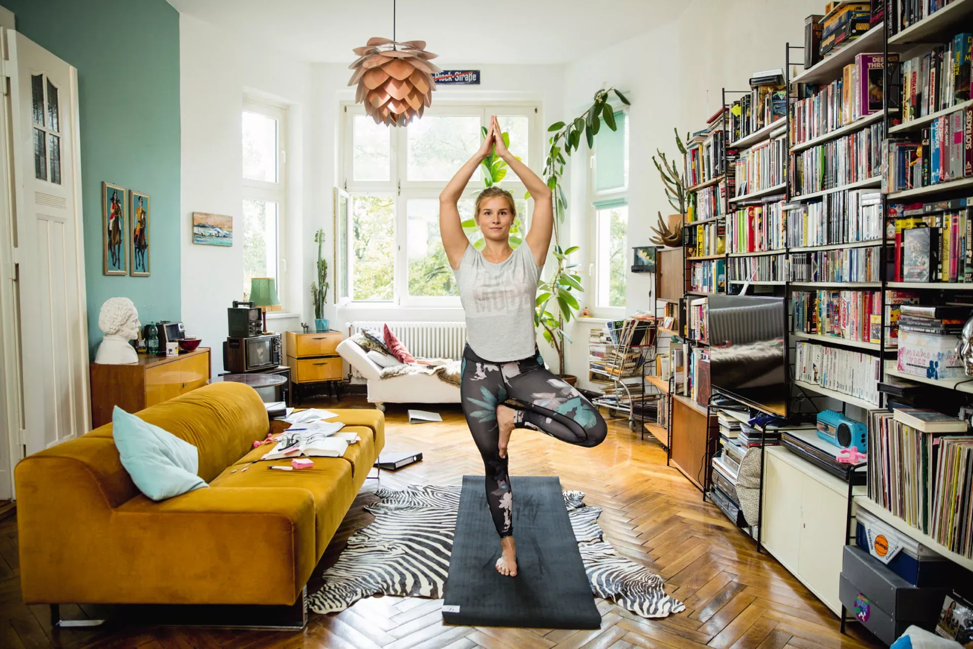 Studentin macht zuhause Yogaübungen auf einer Matte. Studentin macht zuhause Yogaübungen auf einer Matte.